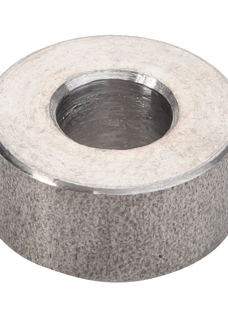 The AGCO Spacer Piece - V836119067, with its cylindrical shape and brushed finish, gleams under the light.