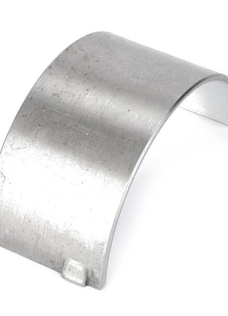 A curved, metal, rectangular-shaped AGCO Conrod Bearing - 3604433M1 with a small tab at one end, placed on a white background.