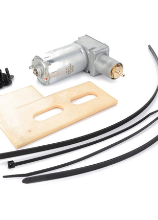 The AGCO | COMPRESSOR - F931502031120, featuring an electric motor with an attached gear, a plastic mounting plate, a set of screws, and four cable ties, is laid out on a white background. No current product description information is available for this item.