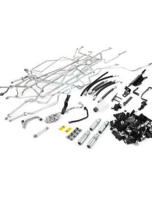 A collection of various metal and plastic car parts, including pipes, tubes, hoses, clamps, connectors, and other small mechanical components arranged on a white background. No current product description available for the AGCO Hydraulic Kit - Acp0633610.
