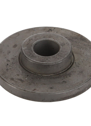 The AGCO Spacer - Acw2848560 is a circular metal disc featuring a central hole and a smaller elevated circular section around it. The surface shows signs of wear and slight discoloration, suggesting that it currently lacks an available product description.