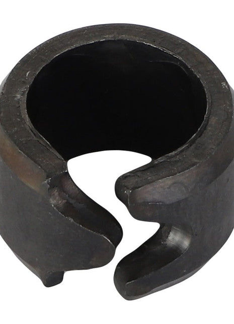A close-up image of an AGCO Spring Tension Bushing - Acp0012100, a dark circular metal part with an open side, resembling a clamp or ring.