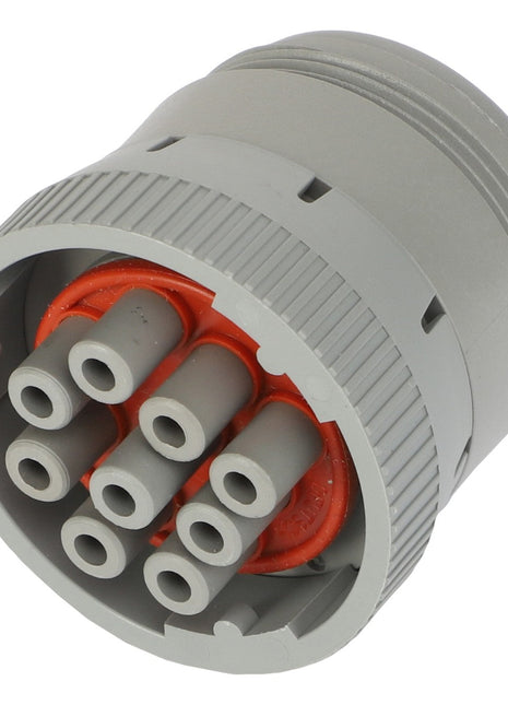 Close-up of a circular gray AGCO | CONNECTOR - AG520349 multi-pin electrical connector, featuring six pin sockets arranged in a circular pattern, with an orange inner lining.