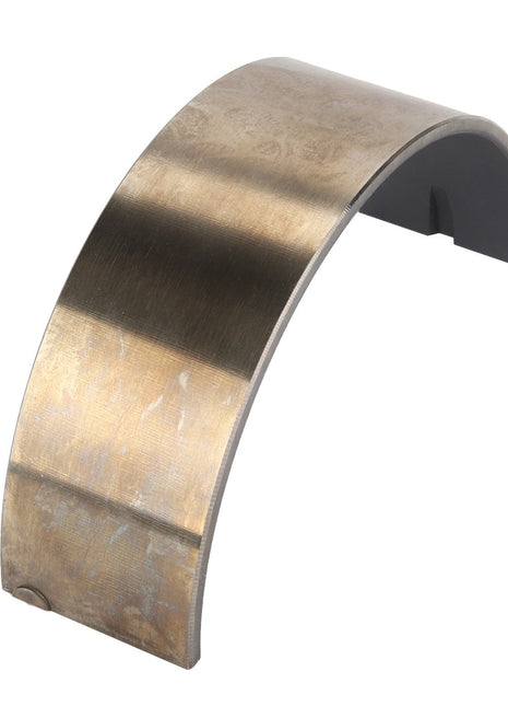 The AGCO | Bearing Shell - Acp0584530 is a curved, metallic piece with a smooth surface and a flat base, engineered for precision in automotive or mechanical applications.