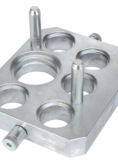 The AGCO CONNECTOR PLATE - ACW0538800 is a rectangular metal plate with five circular holes and three cylindrical pegs protruding from the surface. Currently, no additional product description information is available.