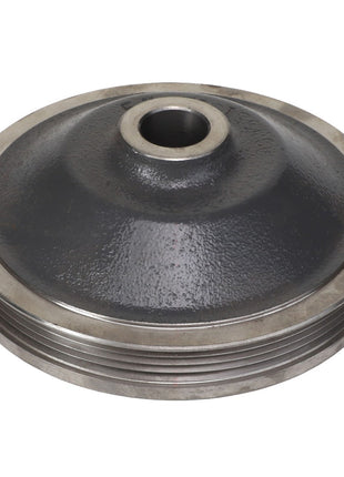 The AGCO Sheave - Acw5513130, a vintage metal pulley featuring a central hole and intricate grooves around its edge, is viewed from an angle, showcasing its robust design and craftsmanship.