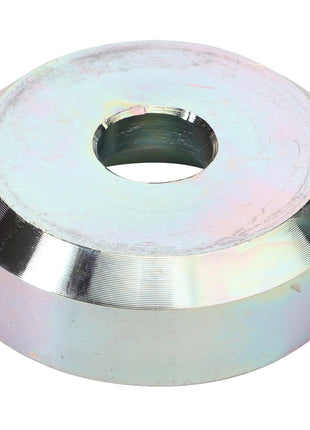 The AGCO Thrust Washer - Fel151183 is a metallic, circular object with a central hole and angled edges. Its surface features a reflective finish with slight color variations.