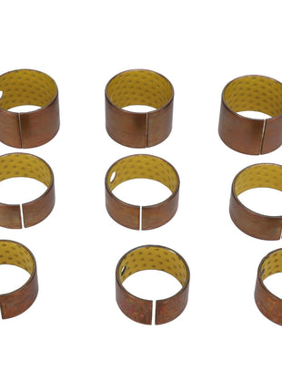 Nine AGCO cylindrical brass bushings (Product Code: AL5018912) with a yellow, textured inner surface, each featuring a split and a hole, arranged in a grid pattern on a white background. No additional information available.