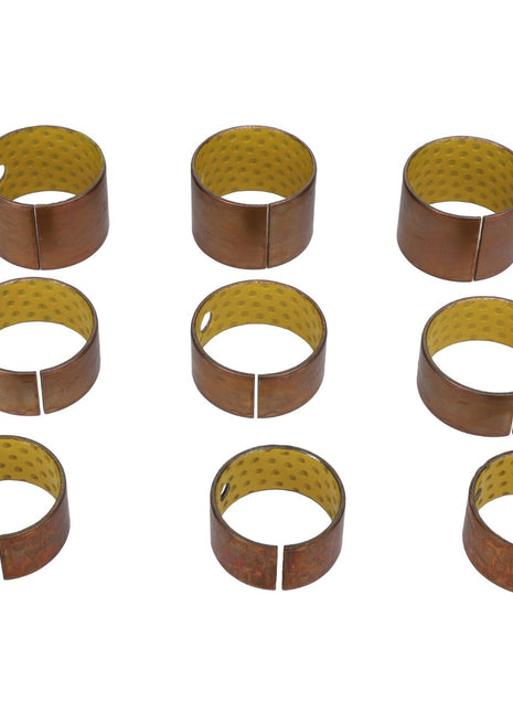 Nine AGCO cylindrical brass bushings (Product Code: AL5018912) with a yellow, textured inner surface, each featuring a split and a hole, arranged in a grid pattern on a white background. No additional information available.