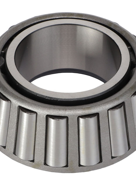 Close-up view of the AGCO BEARING CONE - AG721071, a metal tapered roller bearing with a polished silver finish, designed to handle both thrust loads and radial loads efficiently, featuring evenly spaced rollers around its circumference.