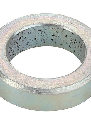 The AGCO | SPACER - CH202-9701 by AGCO is a metal gasket with a cylindrical shape, featuring a hollow center and a surface speckled with dark spots. No current product description information is available.