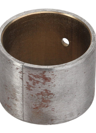 The AGCO BUSH - ACY1514130, a cylindrical metal bushing from the AGCO brand, features a small hole and a slightly worn, tarnished surface, reflecting its status due to the lack of current product description information.