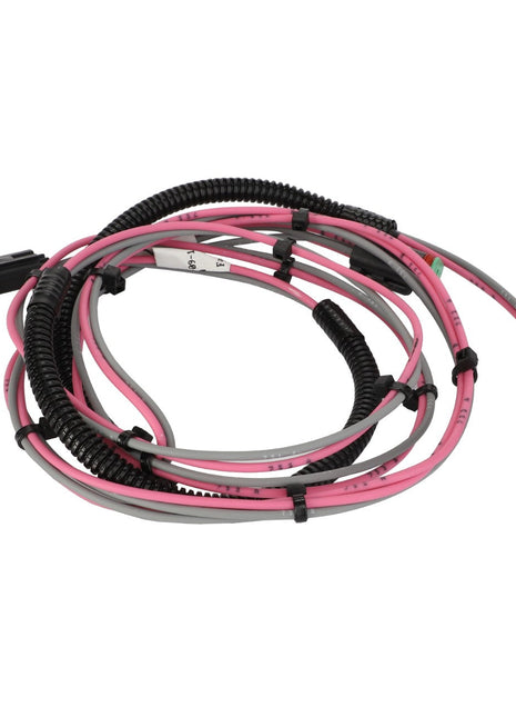 The AGCO Harness, Lighting - AG134870 is a coiled wiring harness with pink, gray, and black cables, featuring plastic connectors at each end to ensure machinery reliability. This AGCO Parts Genuine Electrics component guarantees optimal integration with your equipment.