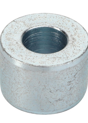 The AGCO | Bush - Acp0323710, a metallic cylindrical spacer featuring a central hole, shows signs of wear and surface scratches.