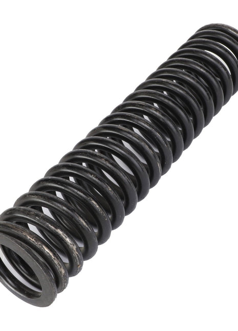 The AGCO SPRING - AG426899, a black-finished coiled metal compression spring with closely wound coils, is displayed lying horizontally against a stark white background.