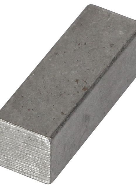 The AGCO | KEY - AG714891 is a rectangular metallic block with a dull, rough surface and visible texture on the ends.
